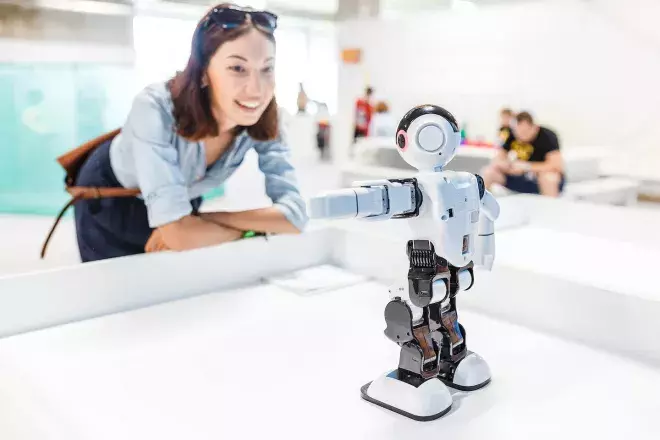 woman looking in awe at robot