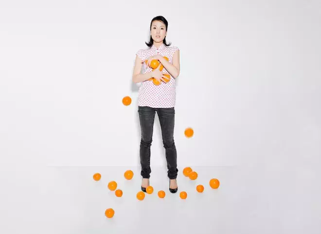 woman struggling to hold oranges