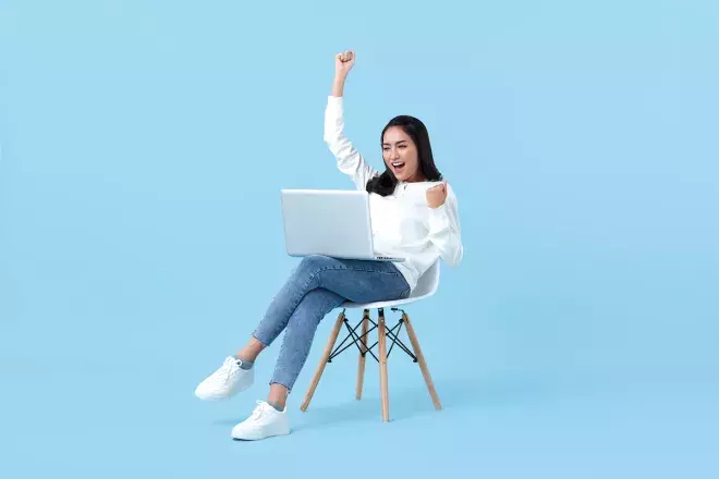 excited woman looking at laptop 