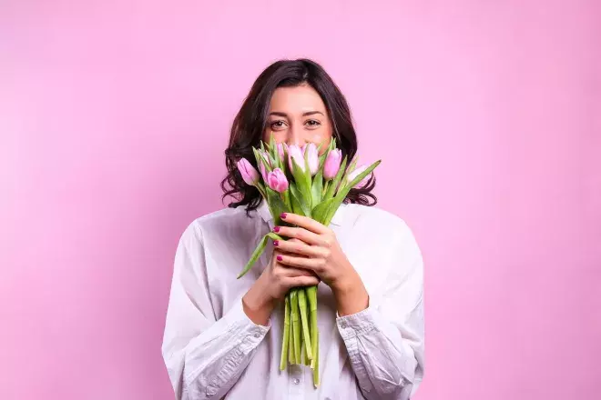 person peeking out of a bouquet of flowers