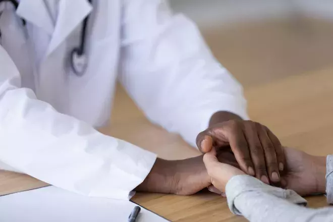 Doctor embracing a patients hand