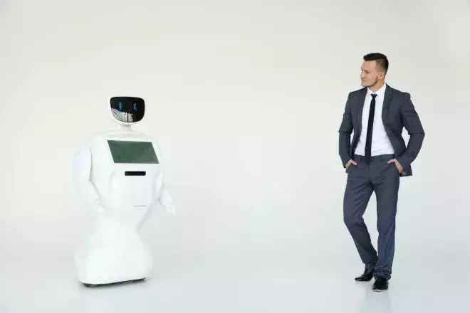 business man looking across room at AI robot