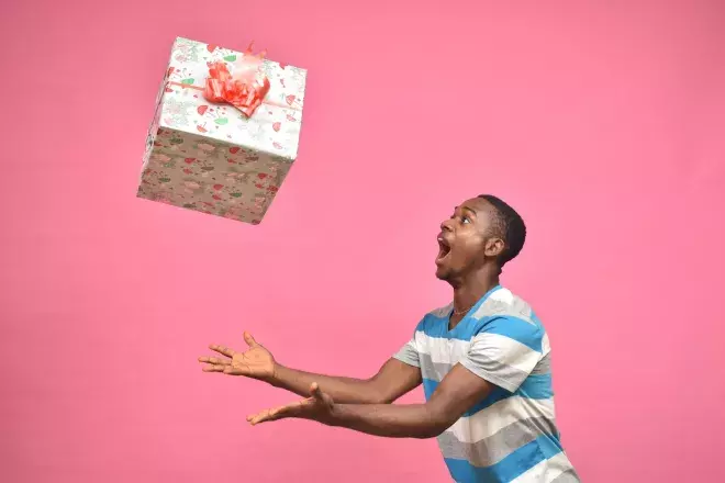smiling person throwing gift into the air
