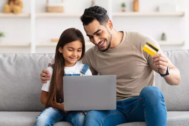 father and daughter shopping online with bankcard