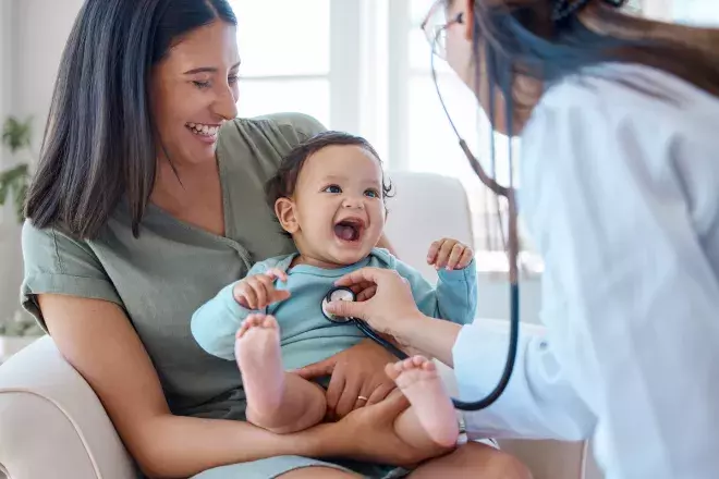 doctor listening to newborn baby's heartbeat