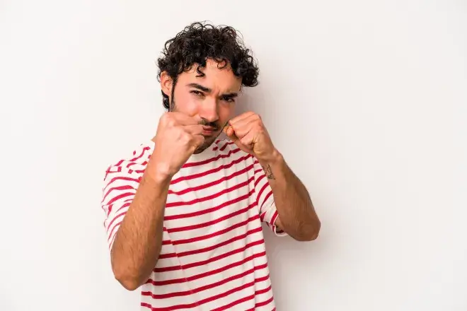 man holding up fists as to throw a punch