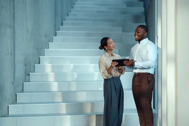 Two business people collaborating at bottom of stairs