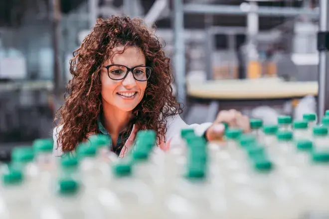 smiling woman working at a soda factory
