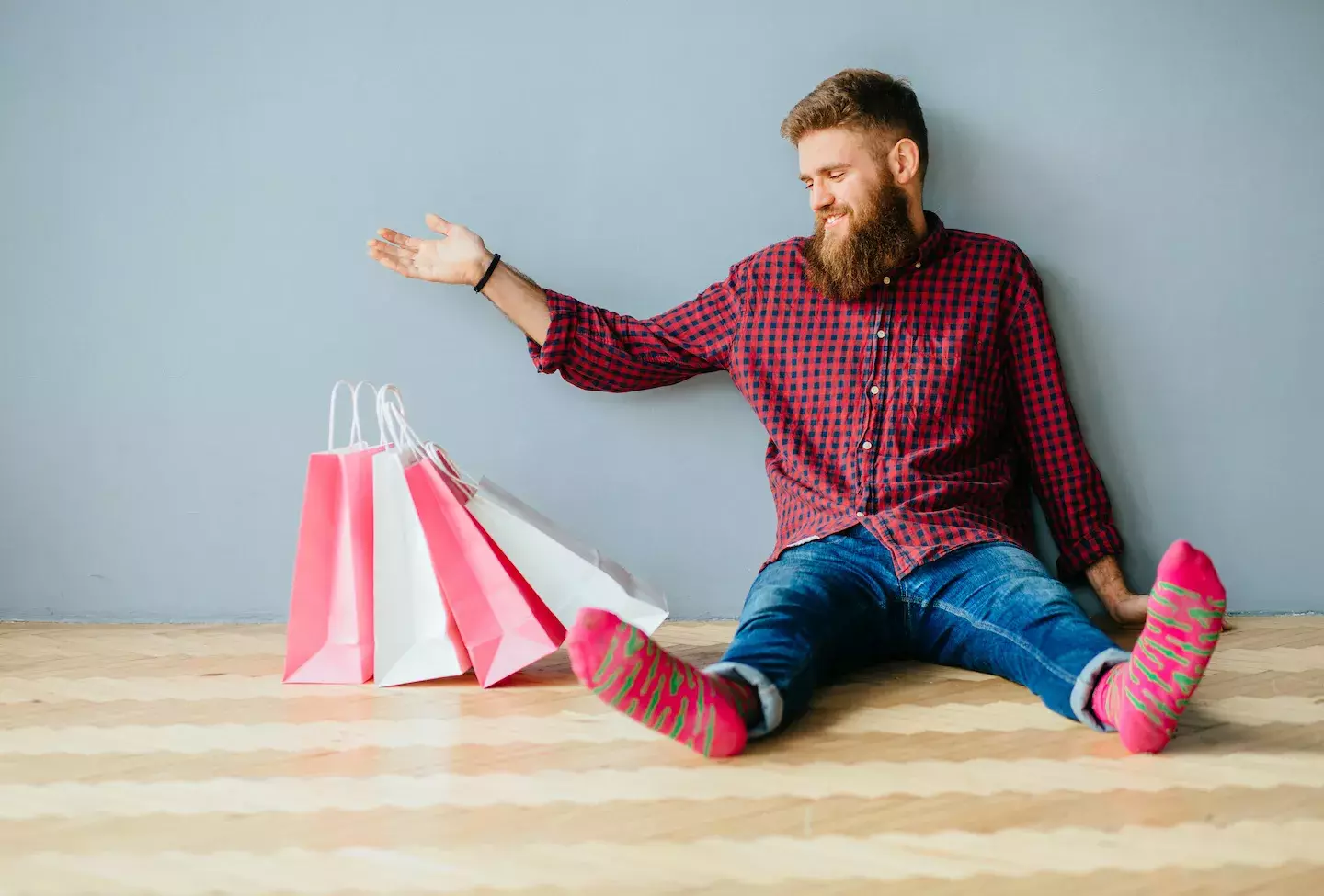man in socks sitting with shopping bags