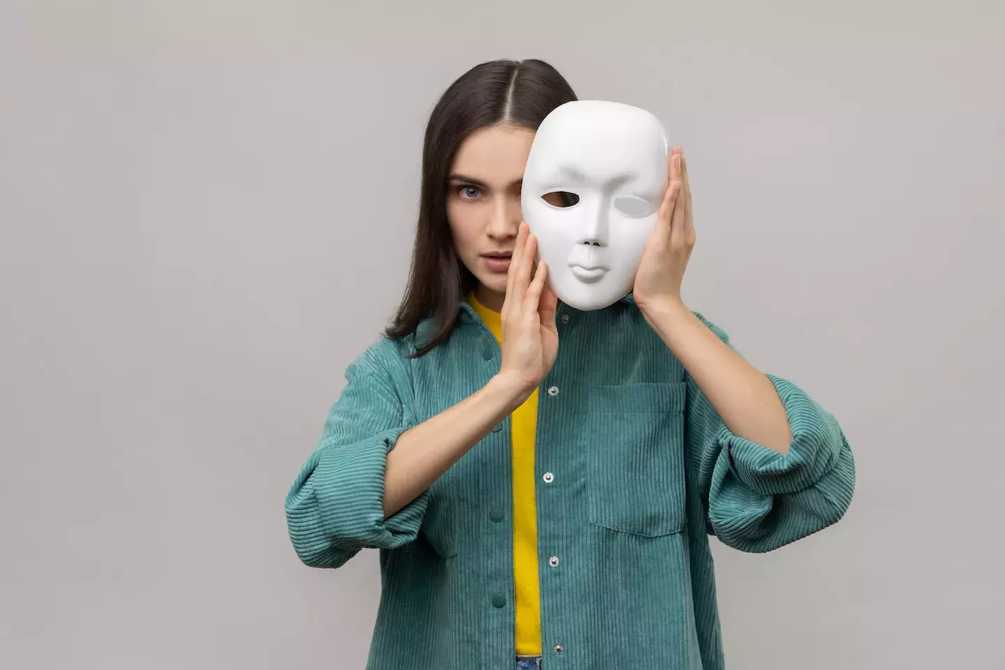 woman hiding behind face mask