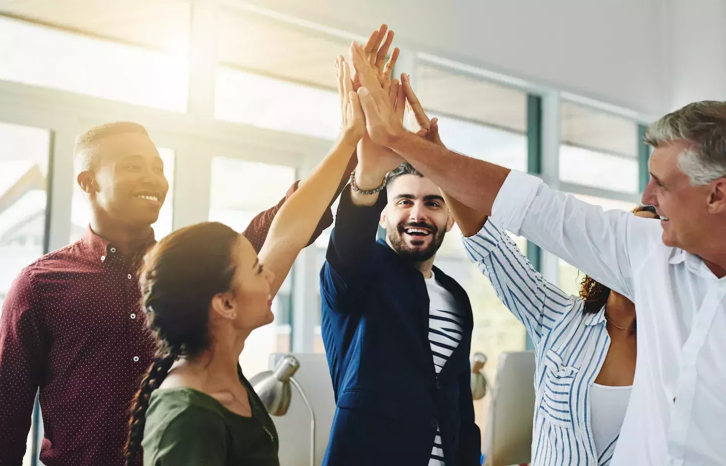 coworkers celebrating achievement with high fives