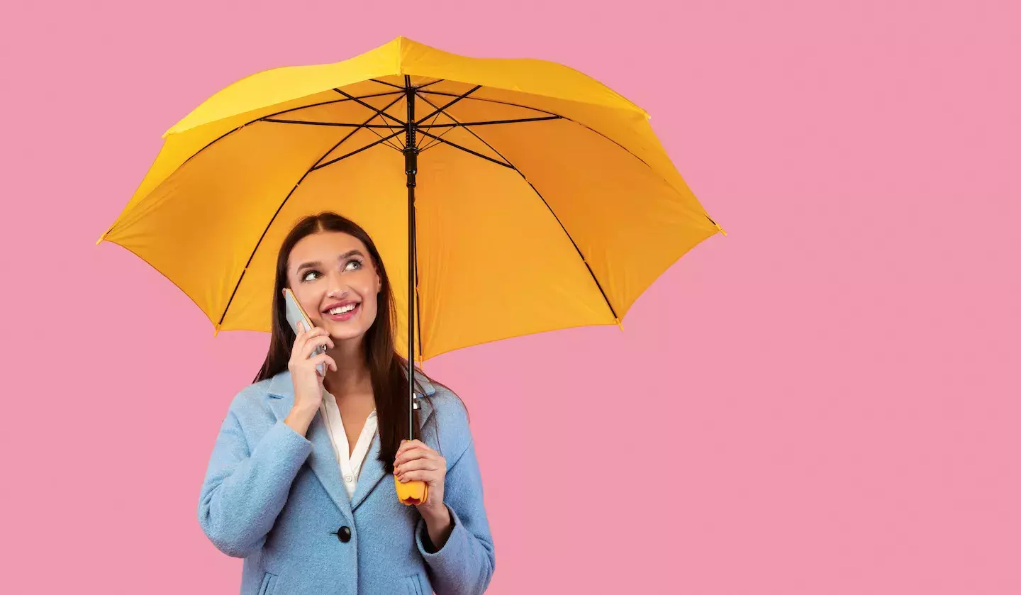 woman on cell phone holding unbrella