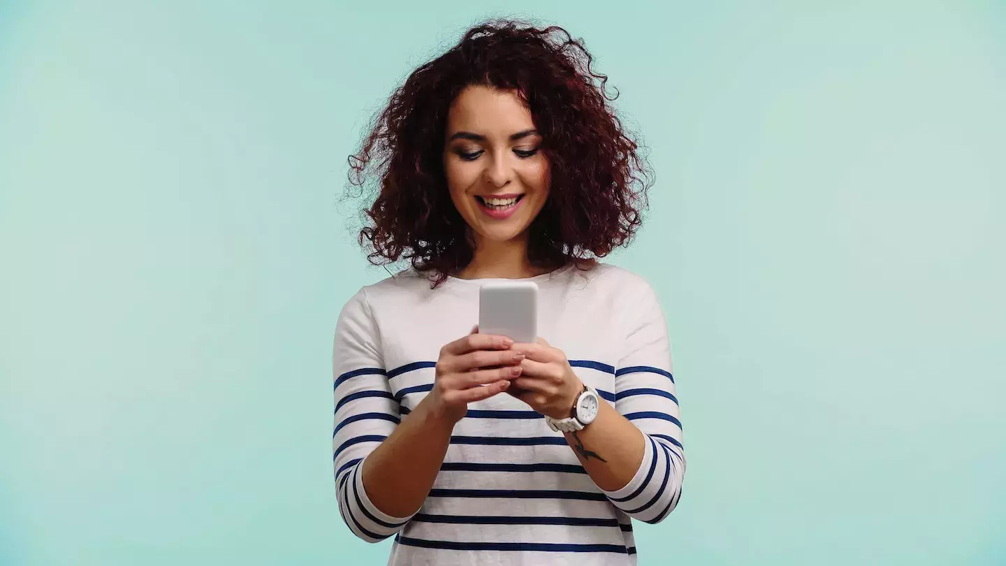 woman looking down at cell phone