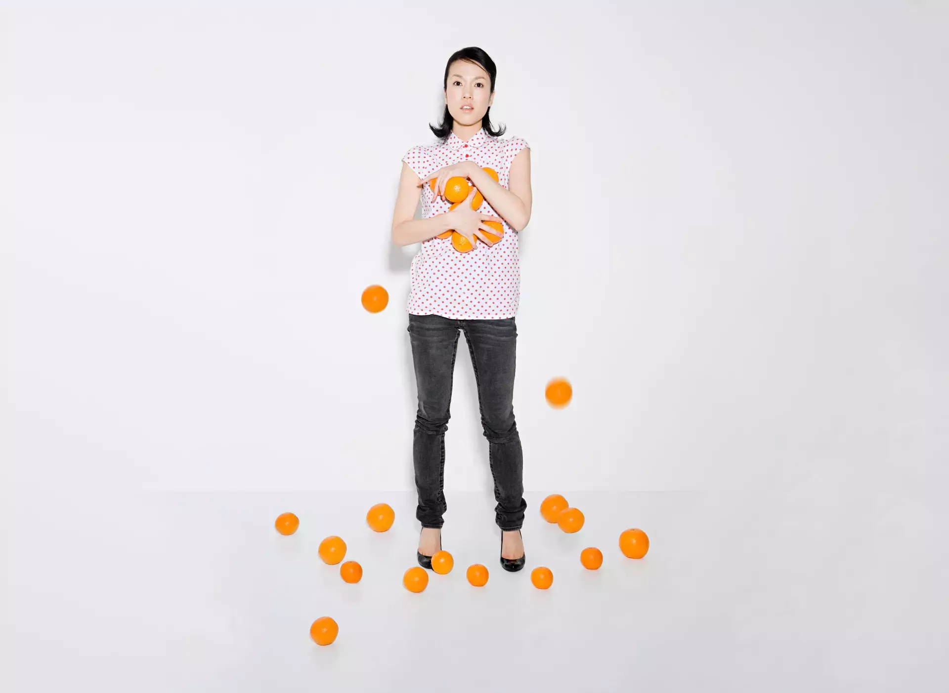 woman struggling to hold oranges