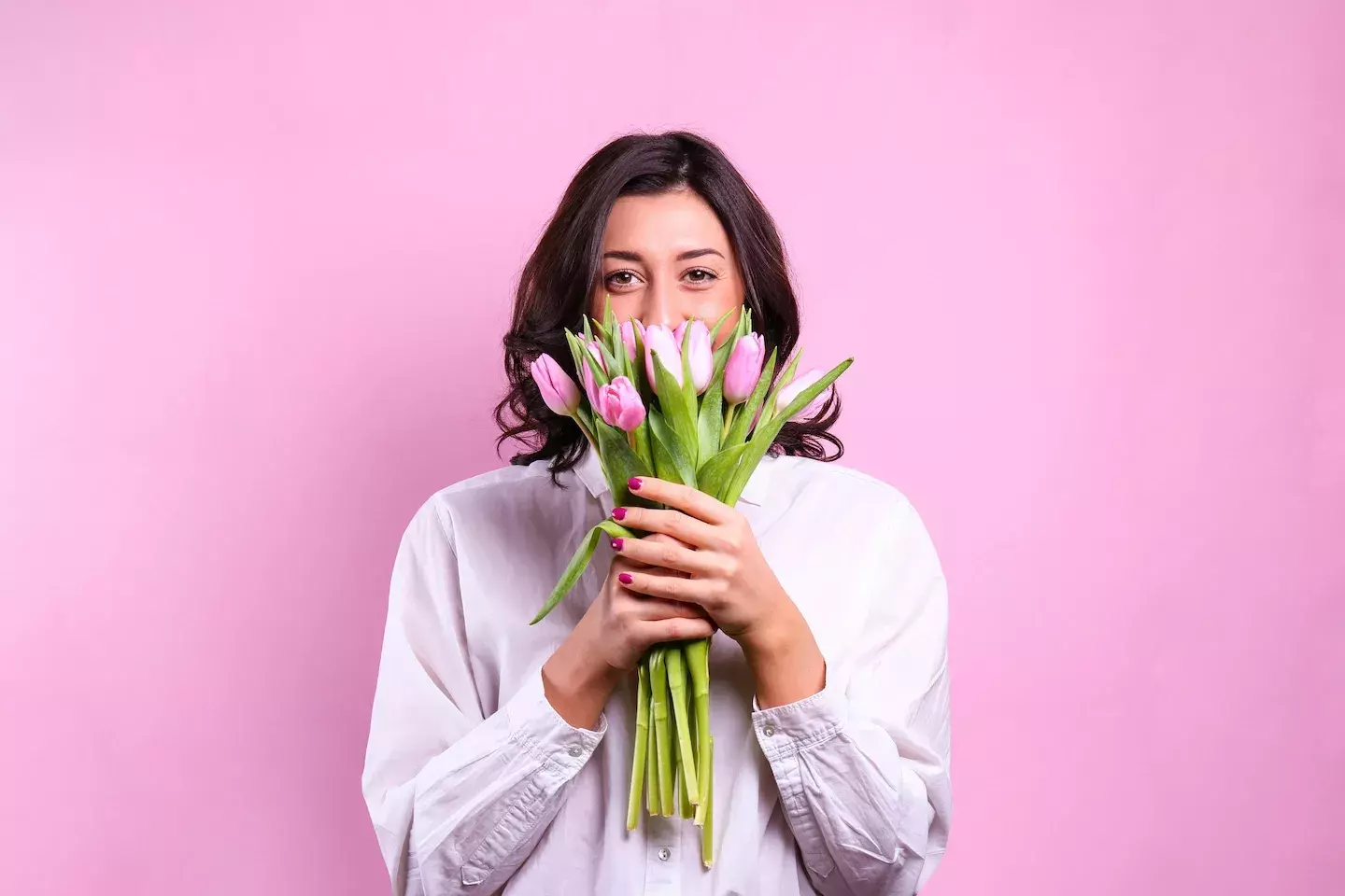 person peeking out of a bouquet of flowers