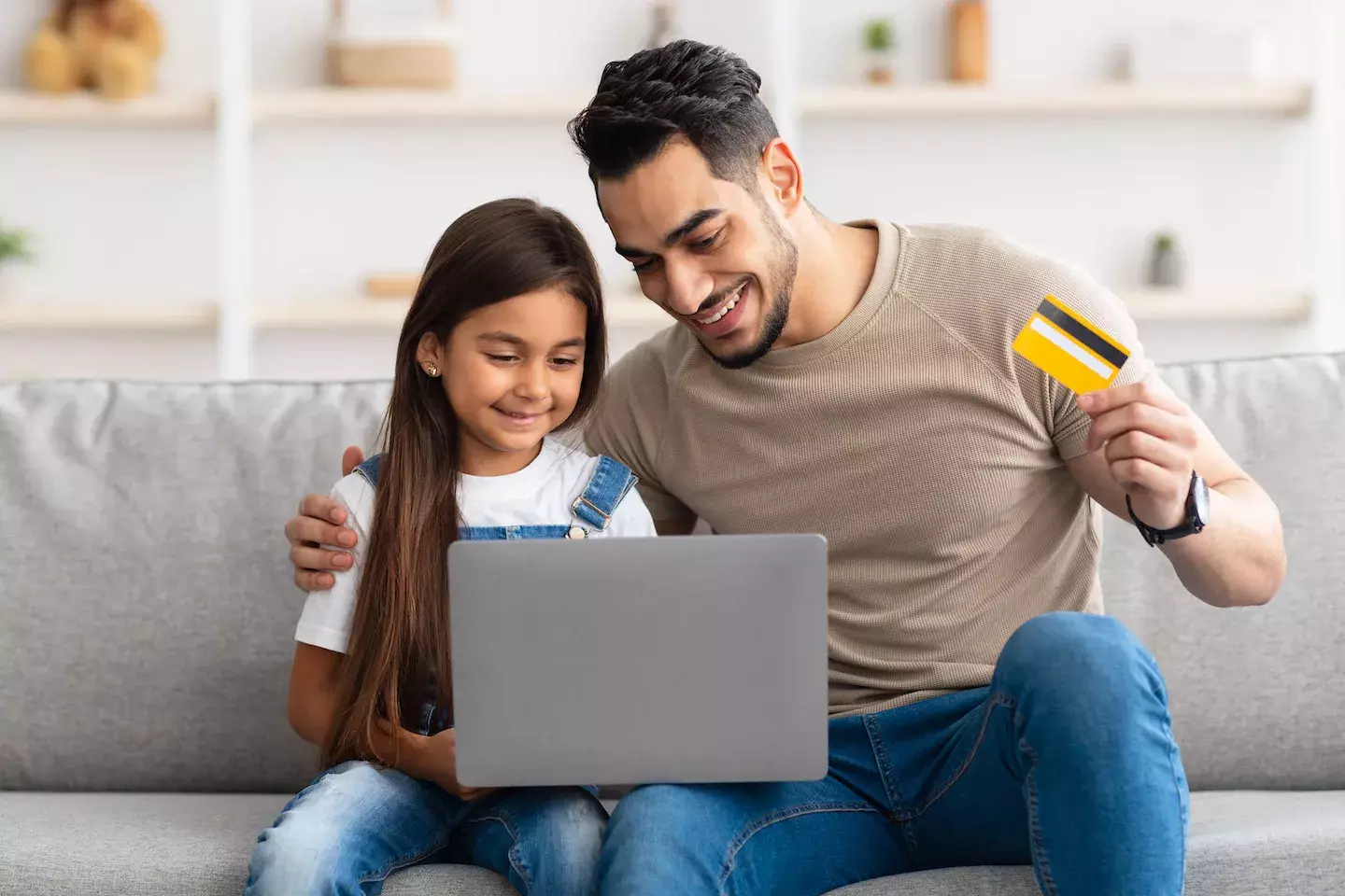 father and daughter shopping online with bankcard