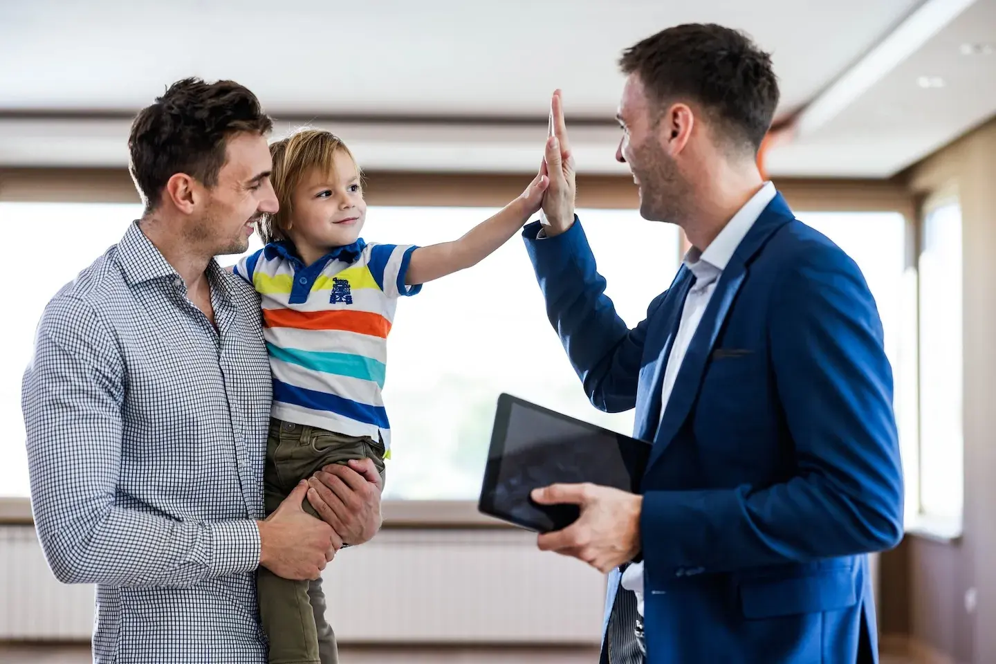 father holding son who is giving high five to lender