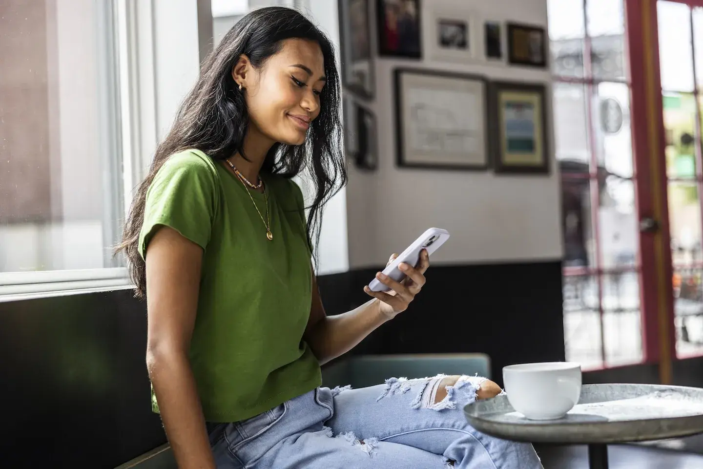 young woman checking phone at cafe
