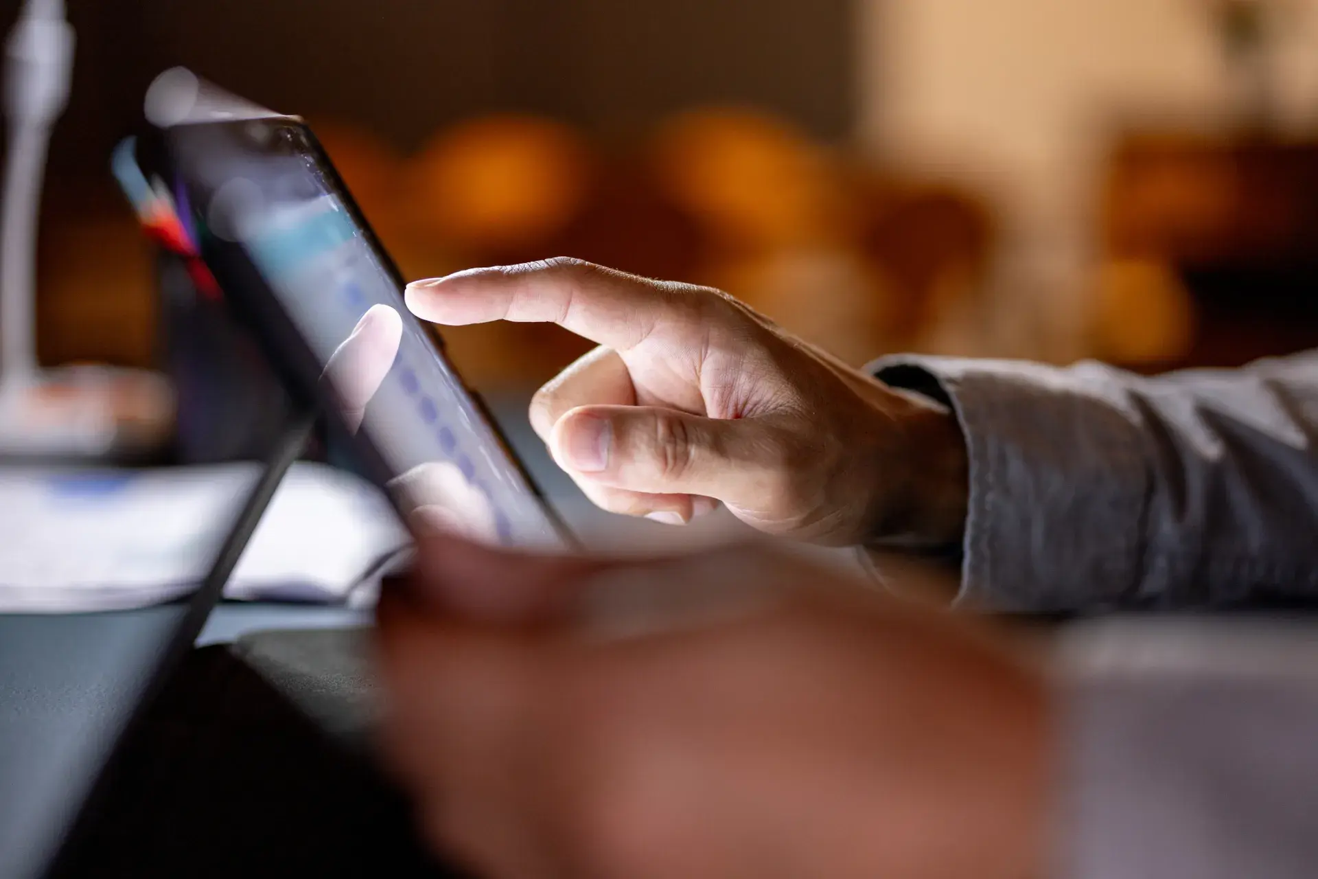 A finger tapping on a tablet screen.